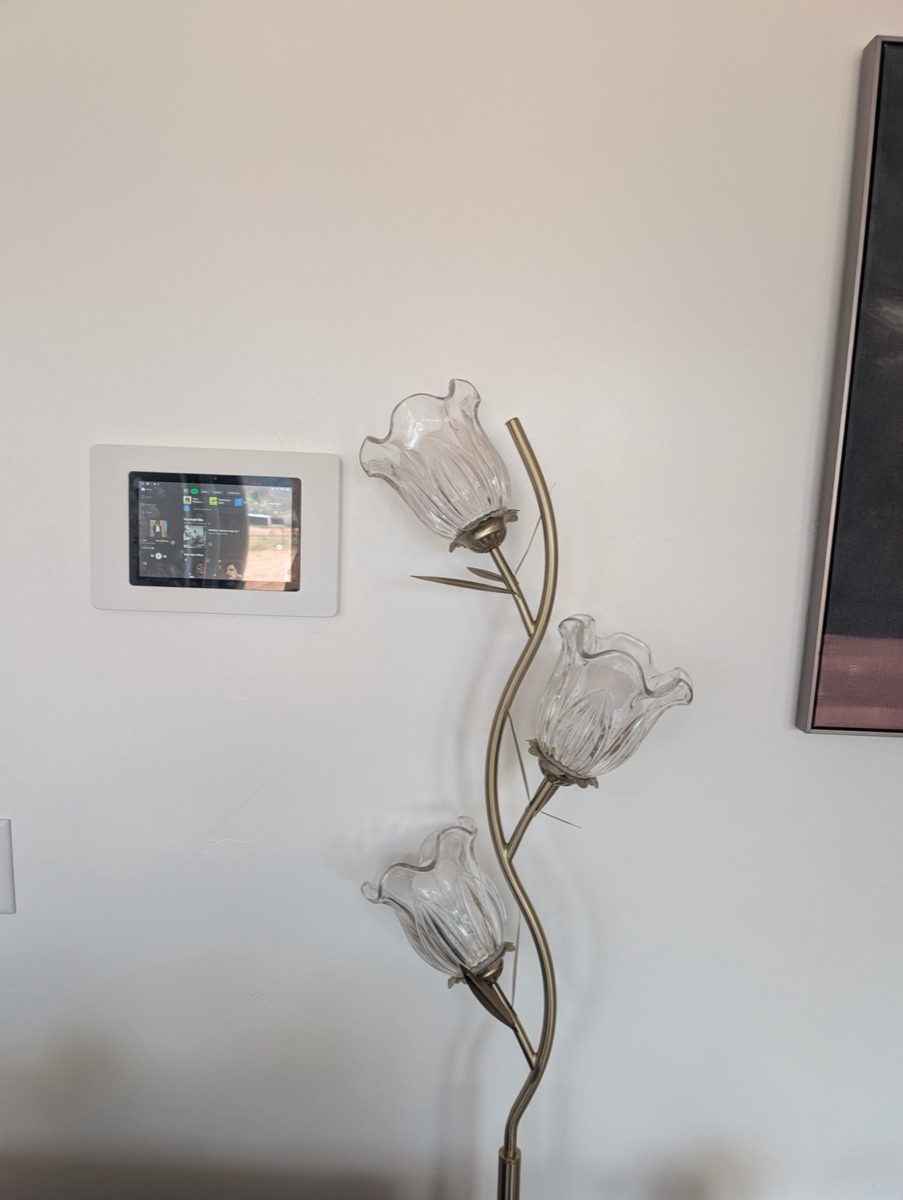 Wall-mounted tablet control dashboard showing music controls